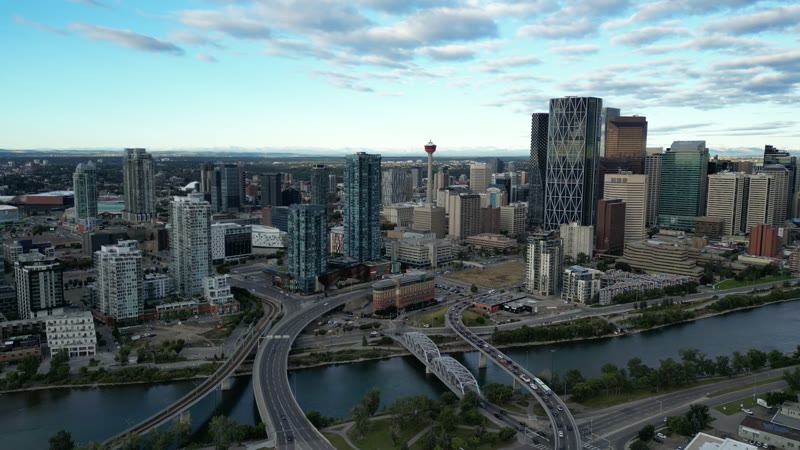 The downtown Calgary skyline from the air, towers catching the last light under a broken sky.